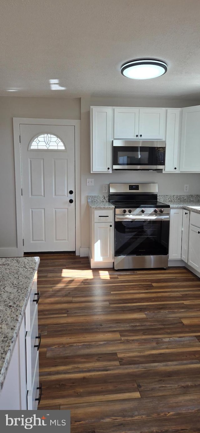 kitchen featuring dark wood finished floors, white cabinets, and appliances with stainless steel finishes