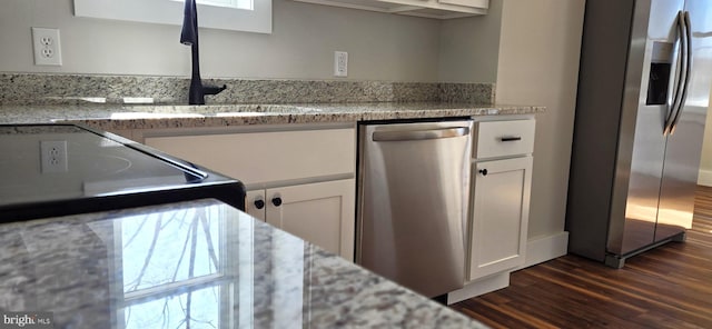 kitchen featuring a sink, stainless steel appliances, dark wood finished floors, and white cabinetry