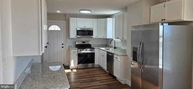 kitchen with a sink, white cabinets, light stone counters, and stainless steel appliances