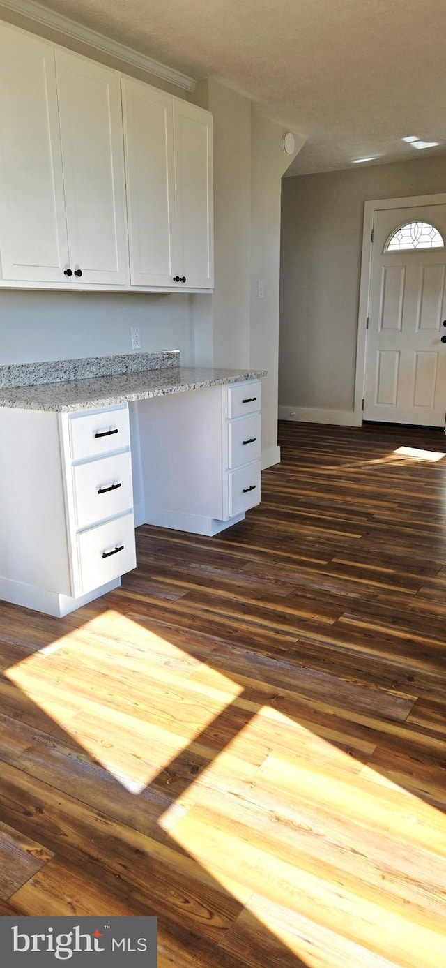 kitchen featuring dark wood finished floors, white cabinets, baseboards, and light stone counters