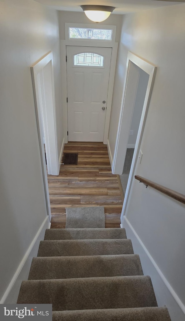 staircase with wood finished floors and baseboards