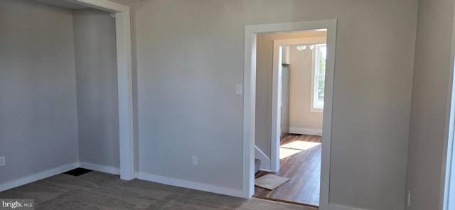 spare room featuring baseboards and dark wood-style floors