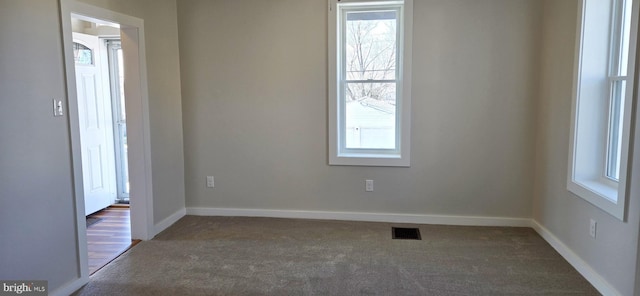 spare room with visible vents, carpet flooring, and baseboards