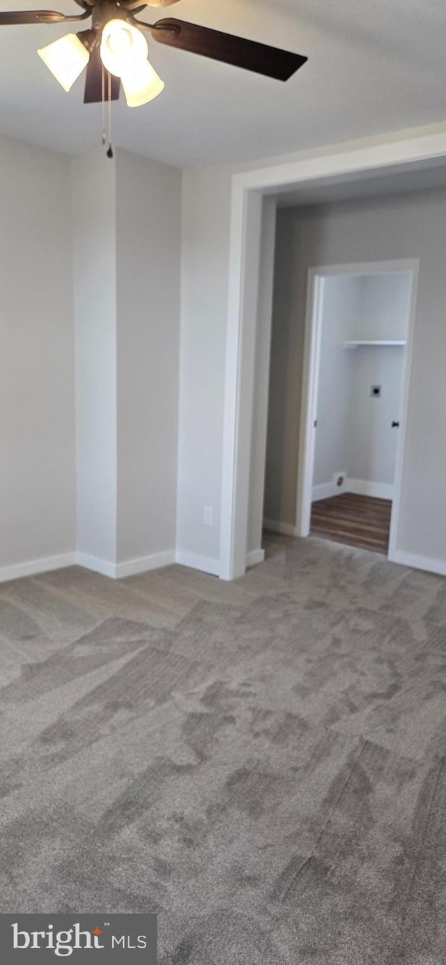 unfurnished room featuring a ceiling fan, baseboards, and carpet floors