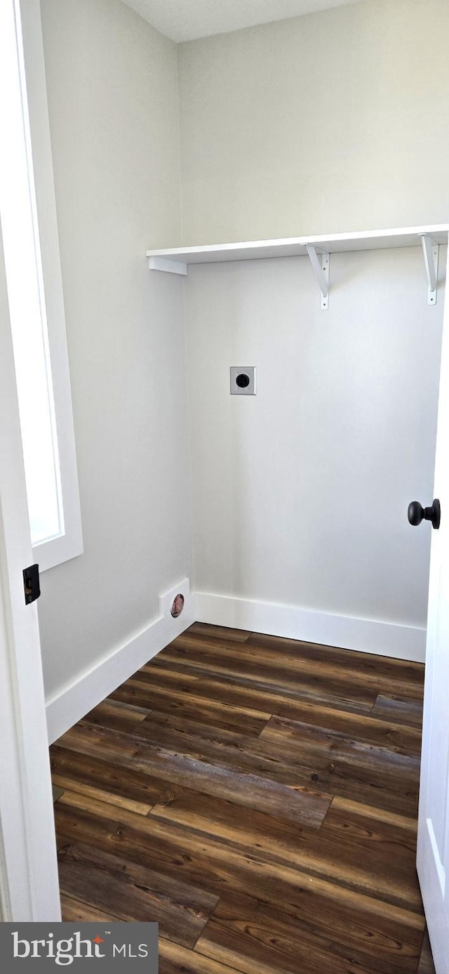 clothes washing area with dark wood finished floors, laundry area, hookup for an electric dryer, and baseboards