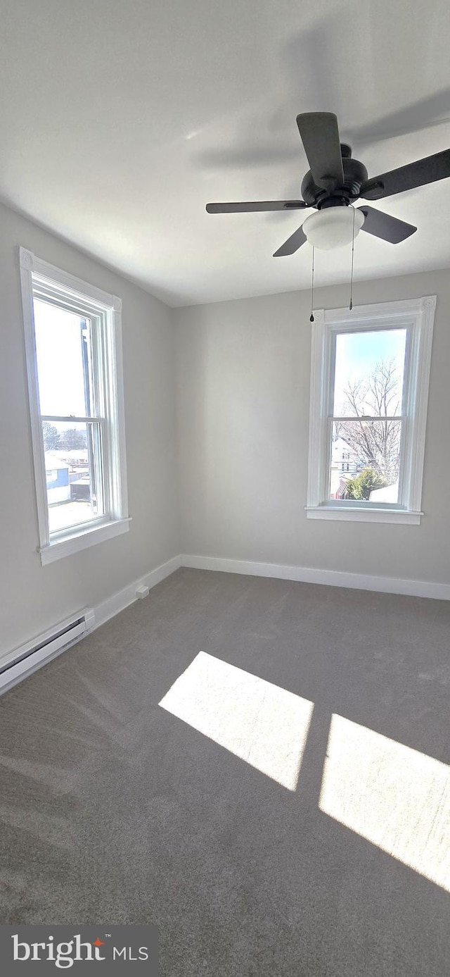 carpeted empty room featuring a baseboard radiator and baseboards