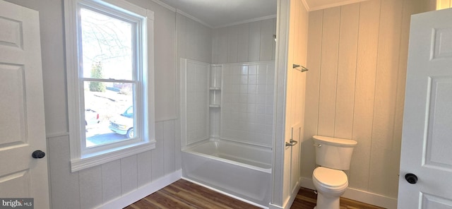 full bath featuring wood walls, toilet, ornamental molding, shower / bathing tub combination, and wood finished floors