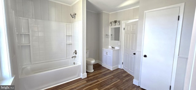 bathroom with tub / shower combination, toilet, ornamental molding, wood finished floors, and vanity