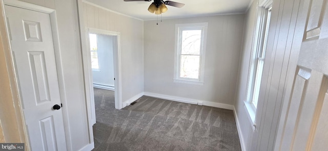 empty room featuring baseboards, dark colored carpet, baseboard heating, and ornamental molding