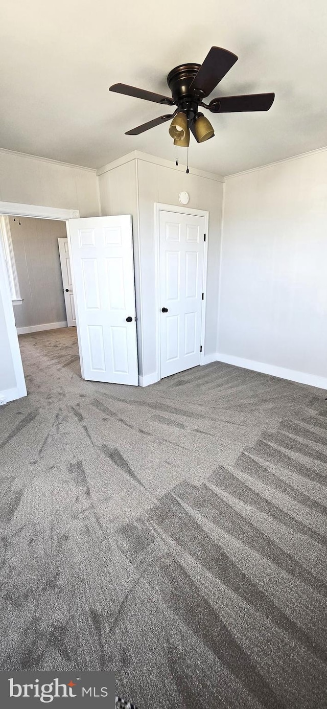 unfurnished bedroom featuring carpet flooring, baseboards, and ceiling fan