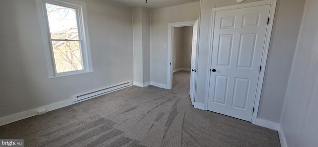 unfurnished bedroom featuring a baseboard radiator, baseboards, and carpet flooring