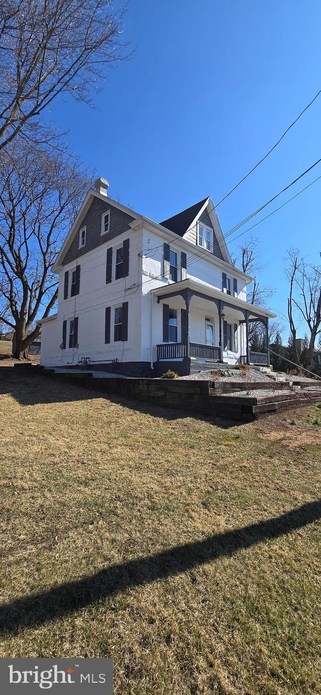 view of front facade featuring a chimney and a front yard