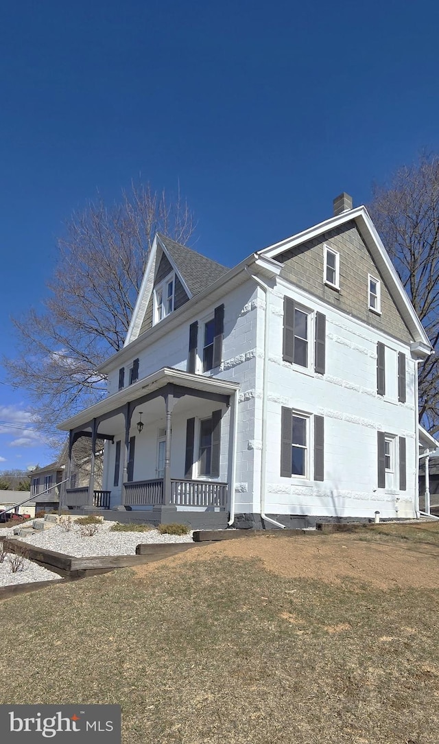 view of front of home with covered porch and a chimney