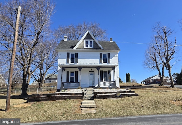 traditional style home featuring a shingled roof, a porch, and a chimney