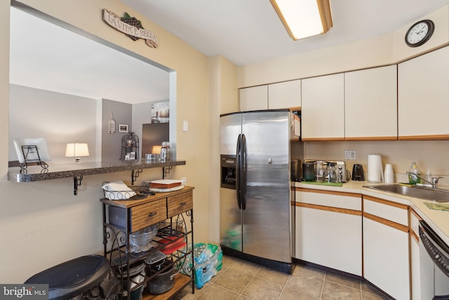 kitchen featuring dishwasher, white cabinets, stainless steel fridge with ice dispenser, and a sink