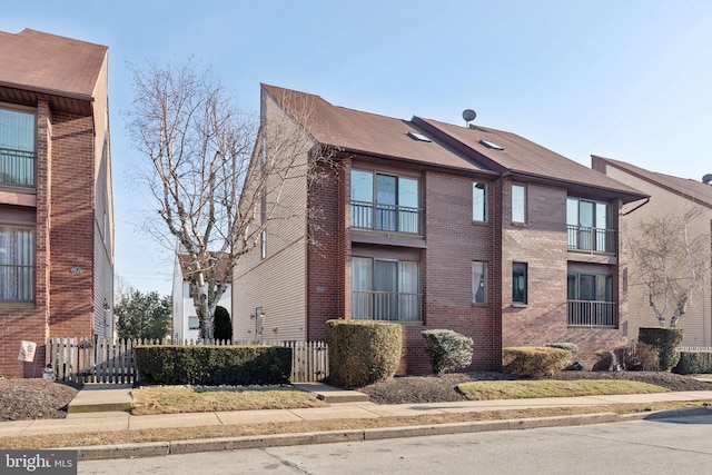 exterior space with brick siding and a fenced front yard