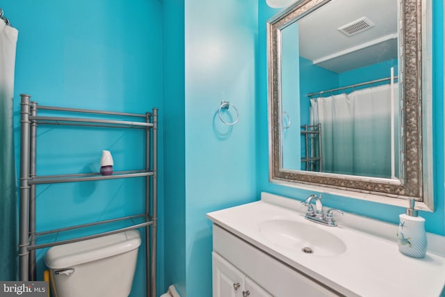 bathroom featuring vanity, toilet, and visible vents