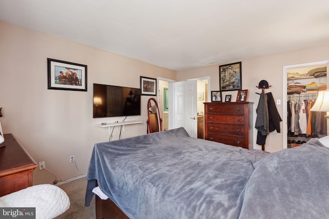 carpeted bedroom featuring a walk in closet and a closet