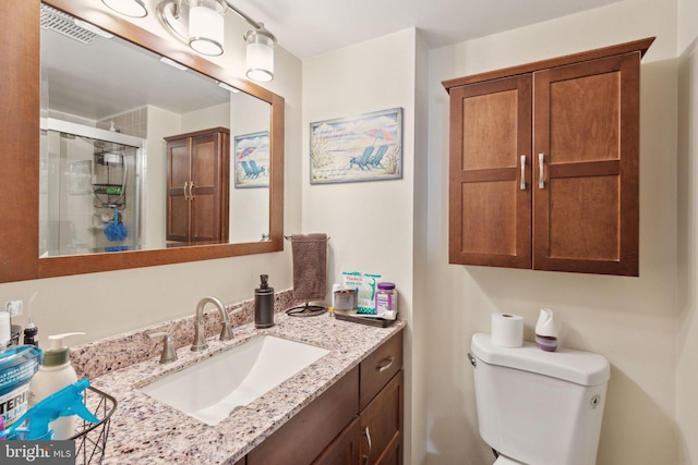 full bath with vanity, a shower stall, toilet, and visible vents