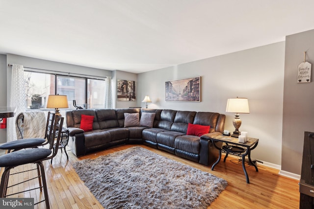 living area with baseboards and light wood finished floors