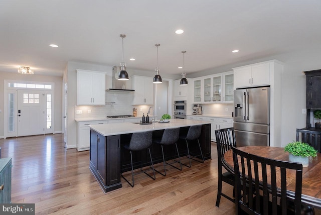 kitchen with light wood-style flooring, appliances with stainless steel finishes, and light countertops