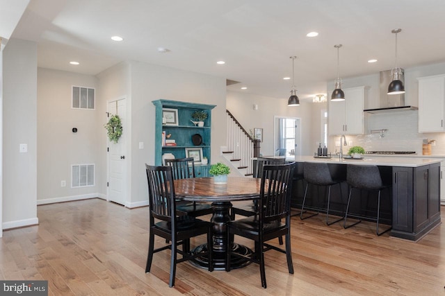 dining space featuring recessed lighting, visible vents, light wood finished floors, and stairs