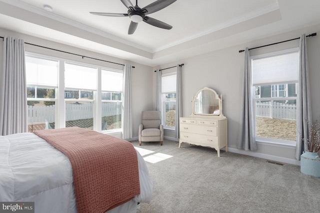 bedroom with ornamental molding, carpet flooring, a raised ceiling, and baseboards