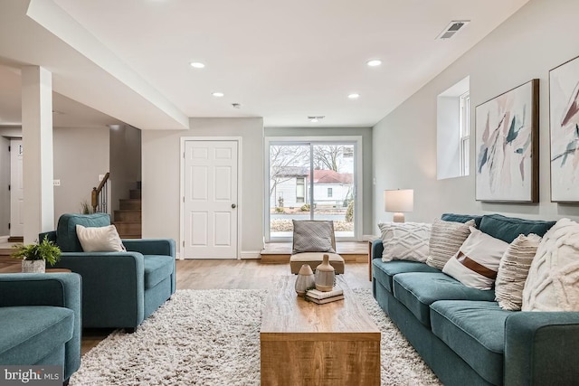 living room featuring stairway, recessed lighting, visible vents, and light wood-style flooring