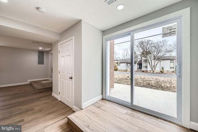 entryway featuring visible vents, electric panel, light wood-style flooring, and baseboards