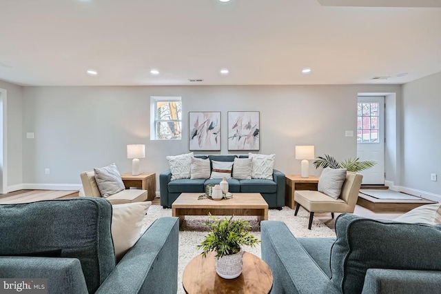 living area featuring recessed lighting, visible vents, baseboards, and wood finished floors