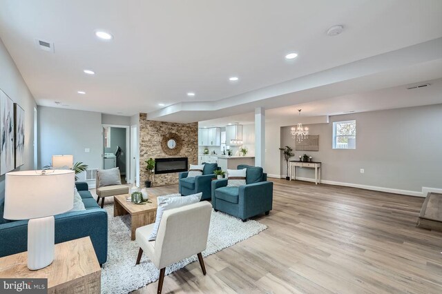 living room with a stone fireplace, light wood-style flooring, recessed lighting, visible vents, and baseboards