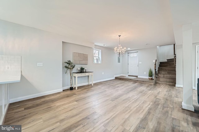 entryway featuring a notable chandelier, stairway, baseboards, and wood finished floors