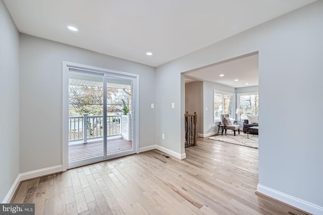 unfurnished room featuring light wood-type flooring, visible vents, baseboards, and recessed lighting