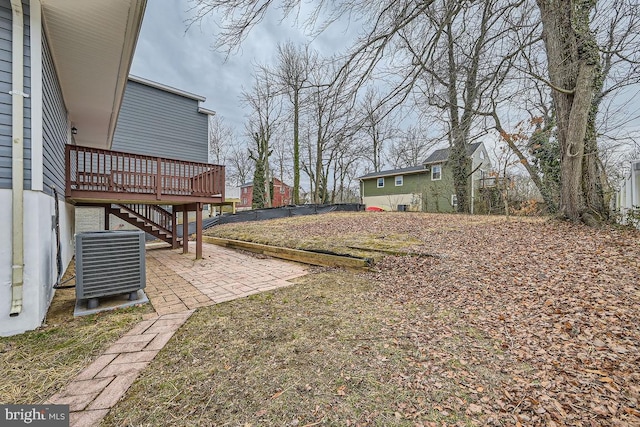 view of yard with a deck, a patio, stairway, and central air condition unit