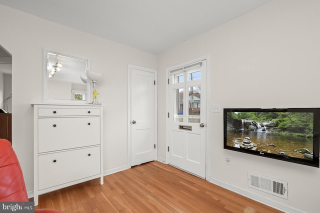 foyer entrance featuring light wood-type flooring, visible vents, and baseboards