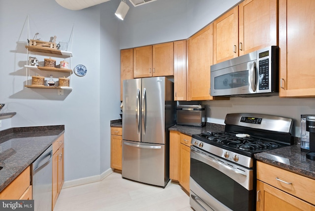 kitchen featuring stainless steel appliances, dark stone countertops, open shelves, and baseboards