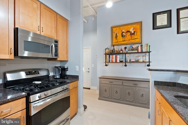 kitchen with appliances with stainless steel finishes, baseboards, dark stone countertops, and open shelves