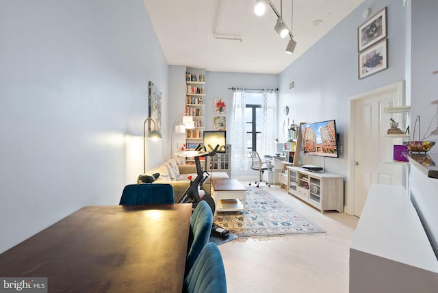 interior space with rail lighting and light wood-style flooring