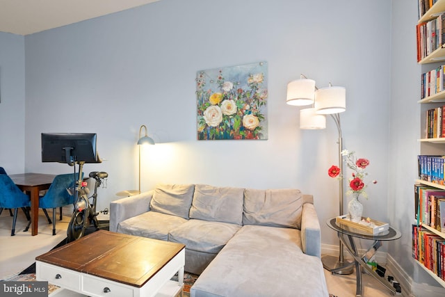 living area with baseboards and wood finished floors