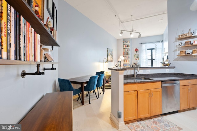 kitchen with open shelves, light wood-style flooring, stainless steel dishwasher, a sink, and dark stone countertops