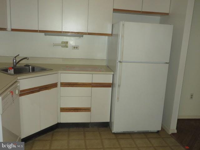 kitchen with light countertops, white appliances, white cabinetry, and a sink