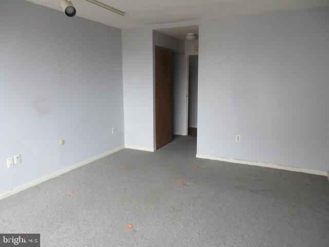 spare room featuring carpet and baseboards