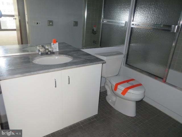 full bath featuring vanity, toilet, and bath / shower combo with glass door