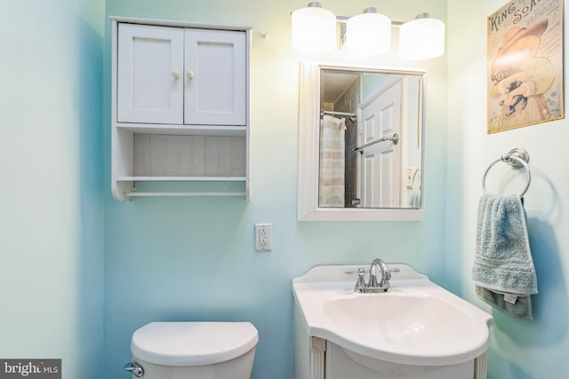 full bath with toilet, curtained shower, and vanity