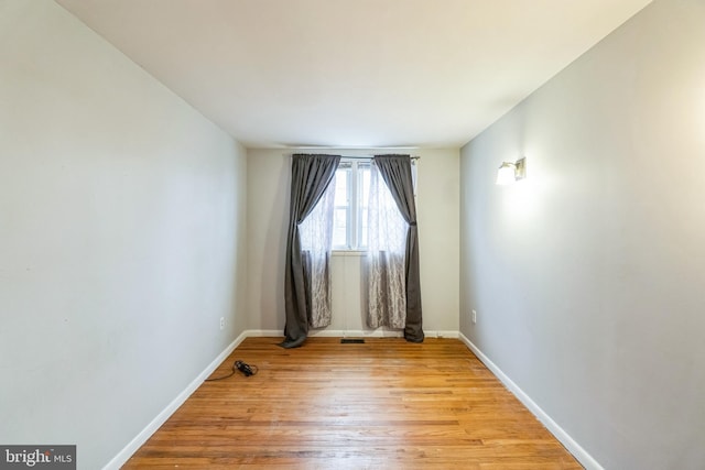 empty room with light wood finished floors and baseboards