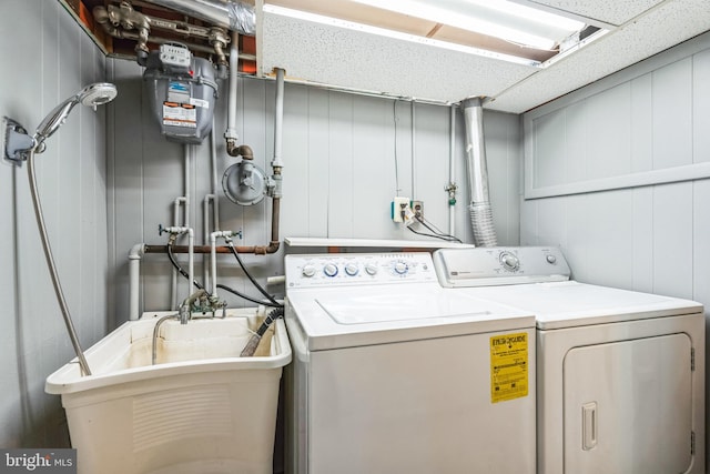 laundry area with laundry area, washer and clothes dryer, and a sink