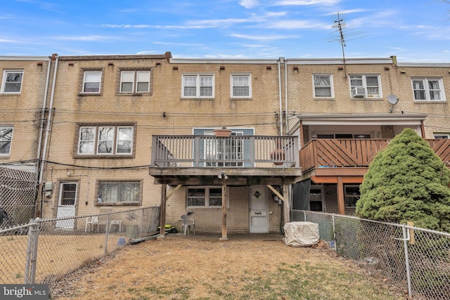 rear view of house with brick siding, fence private yard, and a wooden deck