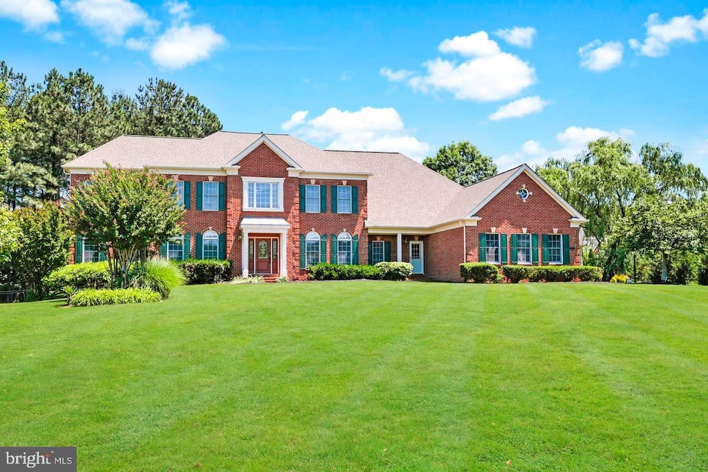 view of front of home with a front lawn and brick siding