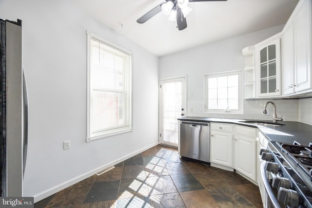 kitchen featuring stone tile floors, a sink, stainless steel appliances, and tasteful backsplash