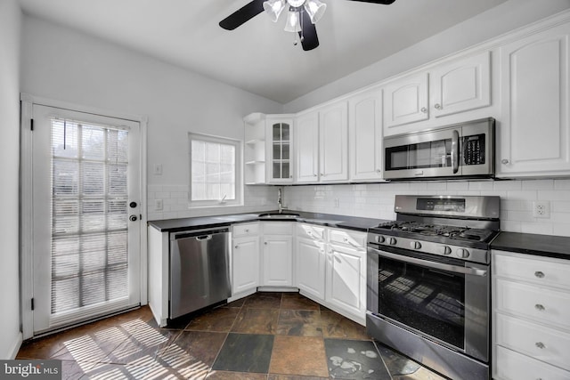 kitchen with open shelves, a sink, stainless steel appliances, white cabinets, and dark countertops